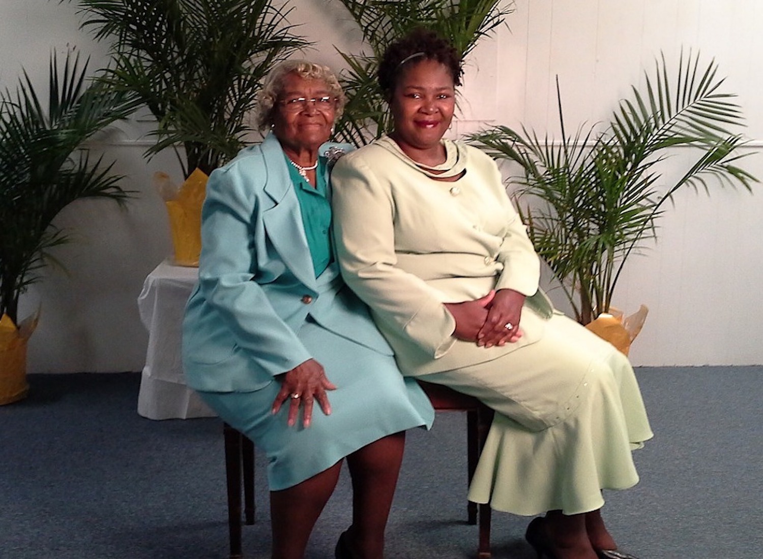 Photo of two generations of Black women seated side-by-side